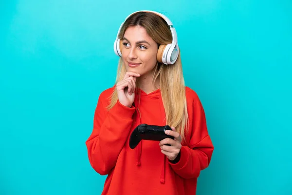 Young Uruguayan Woman Playing Video Game Controller Isolated Blue Looking —  Fotos de Stock