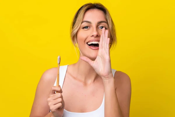 Młoda Urugwajka Myjąca Zęby Odizolowana Żółtym Tle Krzycząc Szeroko Otwartymi — Zdjęcie stockowe