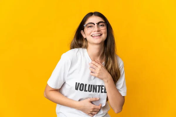 Joven Voluntaria Aislada Sobre Fondo Amarillo Sonriendo Mucho —  Fotos de Stock