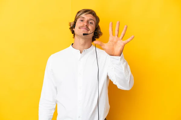 Telemarketeer Man Werkt Met Een Headset Geïsoleerd Gele Achtergrond Tellen — Stockfoto