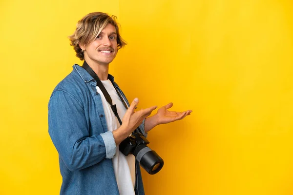 Mladý Fotograf Izolovaný Žlutém Pozadí Natahuje Ruce Stranu Pro Pozvání — Stock fotografie