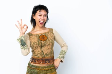 İzole edilmiş beyaz arka plan üzerinde genç Uruguaylı kız parmaklarıyla tamam işareti gösteriyor.