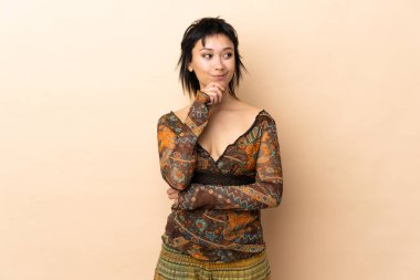 Hintli kadın bej arka planda izole edilmiş ve yukarı bakıyor