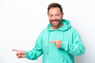 Beyaz arka planda izole edilmiş orta yaşlı beyaz adam şaşırmış ve işaret ediyor.
