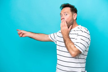 Orta yaşlı, beyaz, mavi arka planda izole edilmiş bir adam.