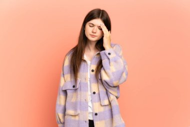 Genç Ukraynalı kız pembe arka planda başağrısı ile izole edilmiş.