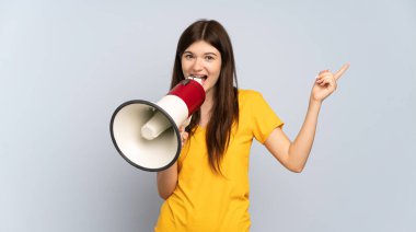 Beyaz arka planda izole edilmiş genç Ukraynalı bir kız megafonla bağırıyor ve işaret ediyor.