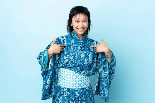 Mujer Joven Que Usa Kimono Sobre Fondo Azul Aislado Apuntándose —  Fotos de Stock