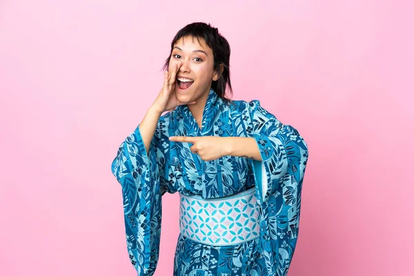 Mujer Joven Con Kimono Sobre Fondo Azul Aislado Apuntando Hacia —  Fotos de Stock