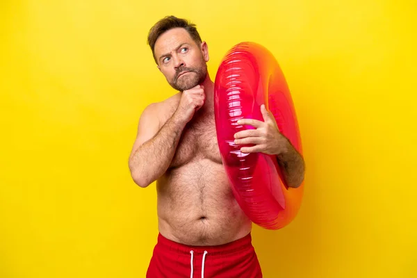 Homem Caucasiano Meia Idade Segurando Donut Inflável Isolado Fundo Amarelo — Fotografia de Stock