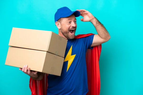 Super Hero Delivery Man Isolated Blue Background Doing Surprise Gesture — 스톡 사진