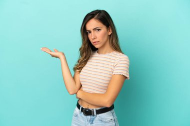 İzole edilmiş mavi arka planı olan genç bir kadın.