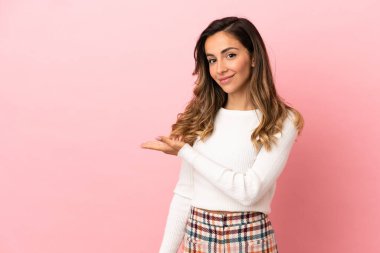 Izole arka plan üzerinde genç kadın doğru gülümseyerek bakarken bir fikir sunan