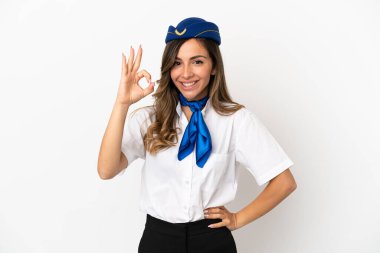İzole edilmiş beyaz arkaplanda uçak hostesi parmaklarıyla tamam işareti gösteriyor.