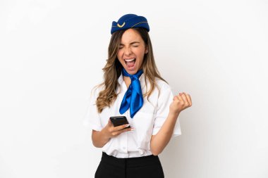 Uçak hostesi izole edilmiş beyaz arka planda ve telefon zafer pozisyonunda.