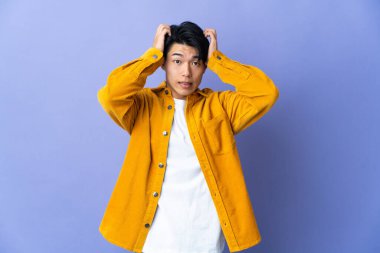 Mor arka planda izole edilmiş genç bir Çinli gergin hareketler yapıyor.