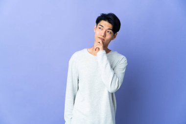 Mor arka planda izole edilmiş genç bir Çinli.