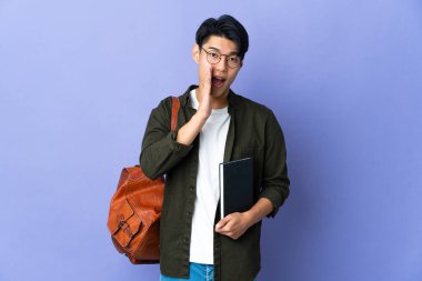 Mor arka planda izole edilmiş genç bir kadın ağzı açık bağırıyor.