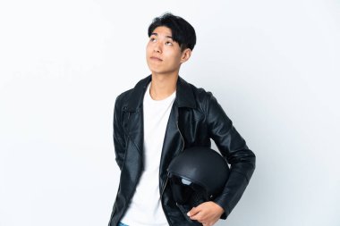 Motosiklet kasklı Çinli bir adam beyaz arka planda izole edilmiş ve yukarı bakıyor.