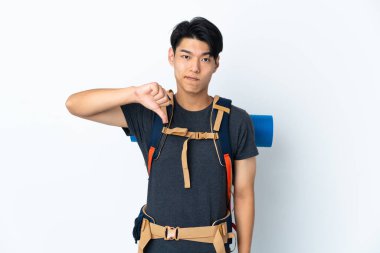 Mountaineer Chinese man with isolated on white background showing thumb down with negative expression