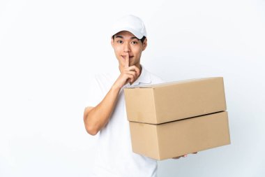 Beyaz arka planda izole edilmiş Çinli bir adam sessizlik işareti gösteriyor. Parmağını ağzına sokuyor.