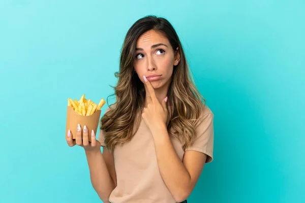 Young Woman Holding Fried Chips Isolated Background Having Doubts While — Stock Fotó