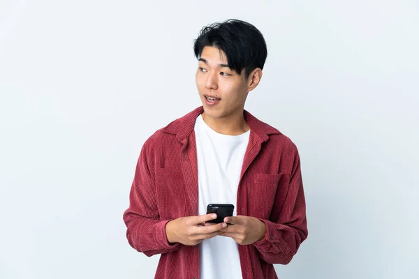 Fiatal Kínai Férfi Elszigetelt Fehér Háttér Segítségével Mobiltelefon Felnéz — Stock Fotó