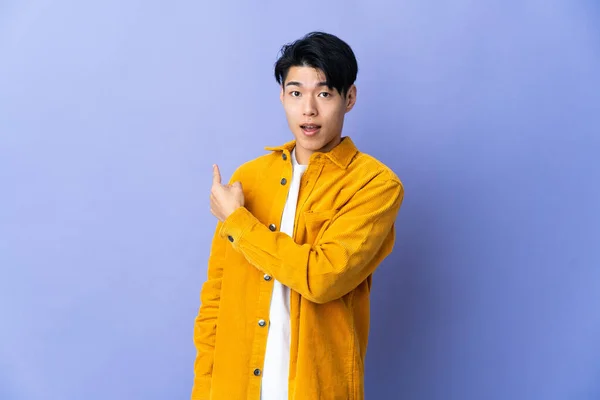 Young Chinese Man Isolated Purple Background Surprised Pointing Side — Stockfoto