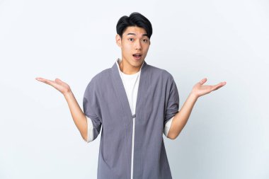 Genç Çinli adam beyaz arka planda izole edilmiş ve şok olmuş bir yüz ifadesi var.