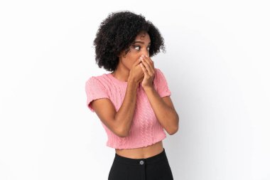 Genç Afrikalı Amerikalı kadın beyaz arka planda izole edilmiş ağzını kapatıyor ve yan tarafa bakıyor.