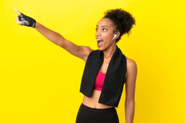 Sarı arka planda izole edilmiş genç Afrikalı sporcu kadın.