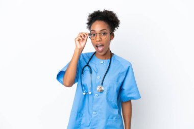 Genç cerrah Afrikalı Amerikalı doktor kadın beyaz arka planda gözlüklü ve şaşırmış.