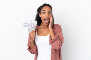 Genç Afrikalı Amerikalı bir kadın beyaz arka planda izole edilmiş bir sürü para alıyor. Şaşırmış ve şok olmuş bir yüz ifadesi var.