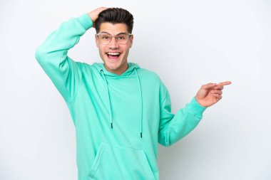 Beyaz fırında izole edilmiş yakışıklı beyaz adam şaşırdı ve parmağını yana çevirdi.