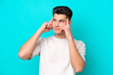 Genç, yakışıklı, beyaz bir adam, mavi fırında izole edilmiş. Şüpheleri ve düşünceleri var.