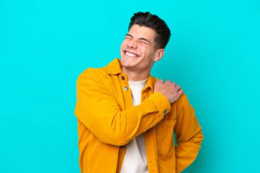 Genç, yakışıklı, beyaz bir adam, mavi bir fırında tek başına, omuz ağrısından muzdarip.