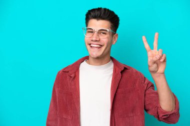 Genç, yakışıklı, beyaz bir adam mavi fırında tek başına, gözlüklü ve her şey yolunda.