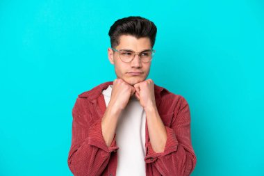 Genç, yakışıklı, beyaz bir adam mavi fırında yalnız, gözlüklü ve yorgun.