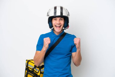 Beyaz arka planda izole edilmiş termal sırt çantalı beyaz tenli genç beyaz adam galibiyetini kutluyor.