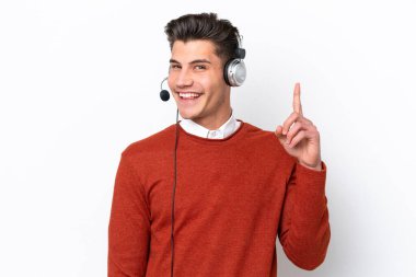 Tele pazarlamacı beyaz arka planda izole edilmiş kulaklıkla çalışan beyaz bir adam parmağıyla işaret etmeyi düşünüyor.