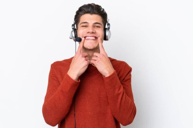 Telemarketer caucasian man working with a headset isolated on white background smiling with a happy and pleasant expression