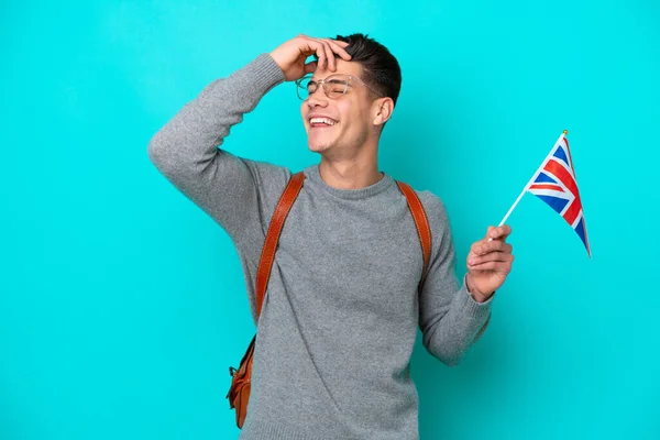 青い背景に隔離された英国の旗を持っている若い白人男性は多くの笑顔 — ストック写真
