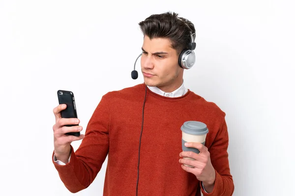 卡卡斯蒂利亚人 拿着独立于白色背景的耳机 拿着咖啡和手机工作 — 图库照片