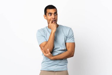 İzole edilmiş beyaz arka plandaki Afrikalı Amerikalı adam gergin ve korkmuş.