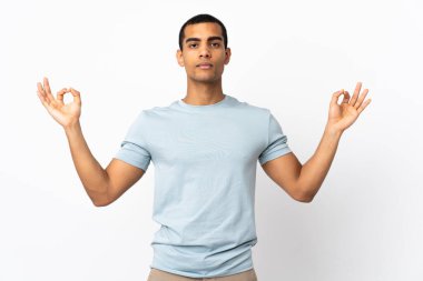Zen pozunda izole edilmiş beyaz arka planı olan Afrikalı Amerikalı bir adam.