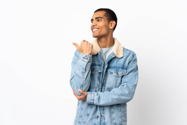 İzole edilmiş beyaz arka planı olan Afrikalı Amerikalı bir adam bir ürün sunmak için kenarı işaret ediyor.