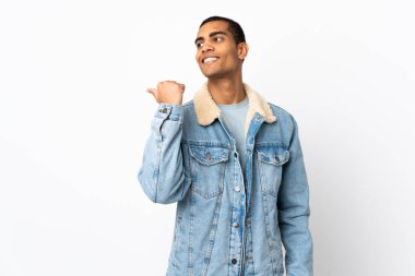 İzole edilmiş beyaz arka planı olan Afrikalı Amerikalı bir adam bir ürün sunmak için kenarı işaret ediyor.