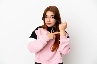 Genç kızıl saçlı kadın beyaz arka planda izole edilmiş, geç kalma jesti yapıyor.