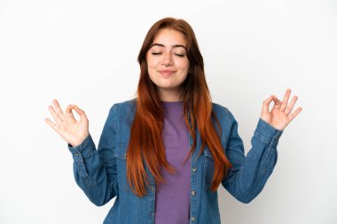 Zen pozisyonunda beyaz arka planda izole genç kızıl saçlı kadın.