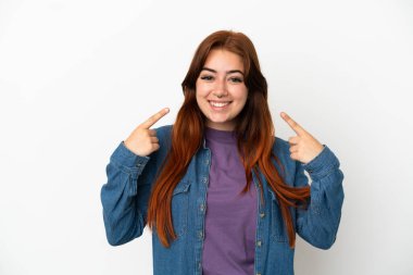 Beyaz arka planda izole edilmiş genç, kızıl saçlı bir kadın baş parmak işareti yapıyor.